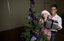 Kate Law and Anthony Callea with a present next to a Christmas tree