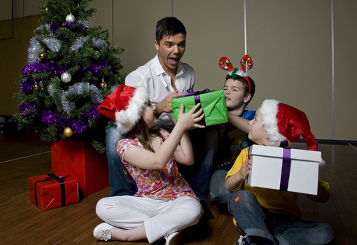 Kate, Nicholas and Jacob Law with Anthony Callea and presents under a Christmas tree