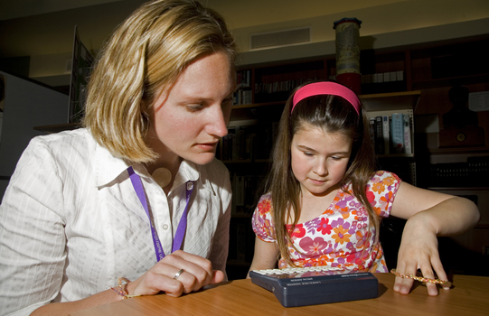 Kate Law using a Franklin Language Master dictionary with Heidi Rogers