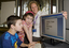 Nicholas Law using a computer in the Browsing Library with his sister Kate and Heidi Rogers looking on