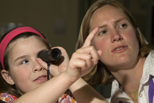 Kate Law holding a monocular telescope with Heidi Rogers