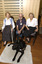 Two seated women in the Kooyong Day Centre with their walking sticks with Colin Pascoe and his dog