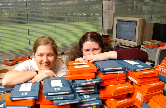 Two females hid behind a pile of cassette books