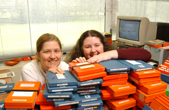 Two females hid behind a pile of cassette books