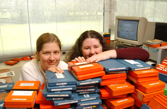 Two females hid behind a pile of cassette books