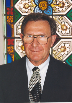 Former RVIB CEO Doug Kent in front of stained glass window at St Kilda Road