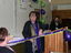 Sharon Muldoon cutting a green and purple ribbon