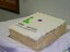 Square cake with 'v' in green and 'a' in purple Braille dots