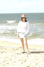 Female in hat and sunglasses at beach