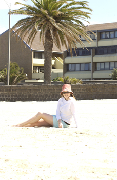 Female in hat and sunglasses at beach