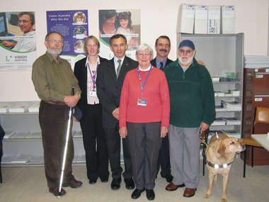 Six people stand together in an office
