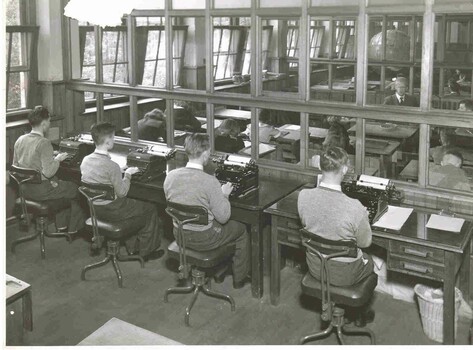 Boys typing on typewriter in class