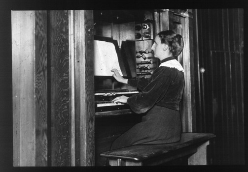 Woman playing organise whilst reading Braille music