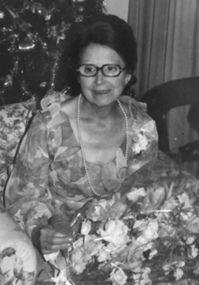 Kitty Rose holds flowers in the lap of her flowery dress