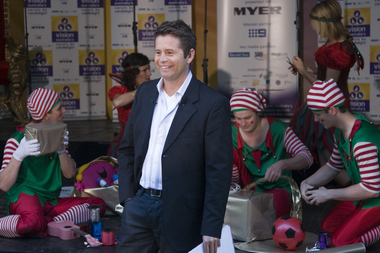 Steve Jacobs with elves wrapping behind him