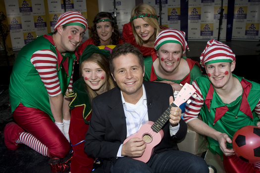 Steve Jacobs with the elves holding toys