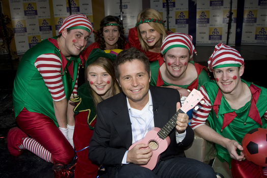 Steve Jacobs with the elves holding toys