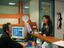 Male receptionist speaks to female at counter - used in end pages