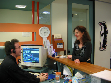 Male receptionist speaks to female at counter - used in end pages