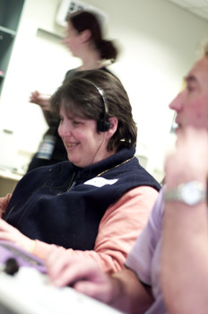 Woman wearing headphones as she types