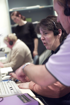Woman wearing headphones as she types