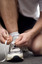Male tying up laces on his running shoe