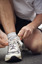 Male tying up laces on his running shoe