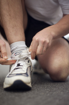 Male tying up laces on his running shoe