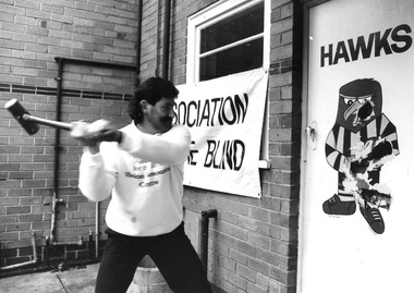 Robert DiPierdomenico using a sledgehammer on a Hawks picture