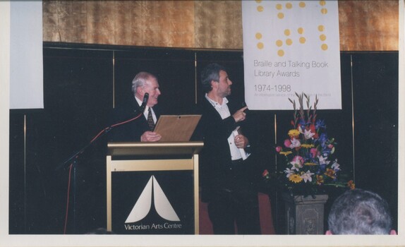 Bib Stillwell and Mark Raphael Baker standing at the podium