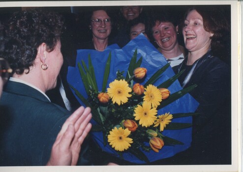 Rose Bluestein is presented with flowers, Elizabeth Woods, Meike Mellars, Robert De Graauw in background
