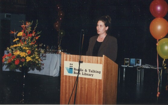 Cate Milte reads from the podium