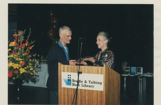 Robert Dessaix accepting his award from unknown female