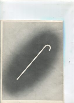 Rear cover with white cane on darkened background on white page