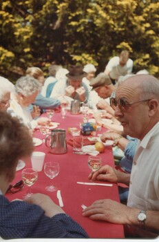 People eating lunch around a long table outside