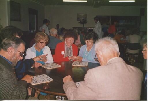 Table with eager Bingo players monitoring their cards