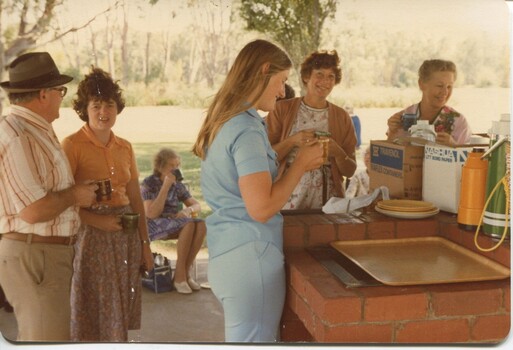 Group of people around BBQs with thermos and supplies