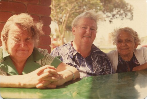 Three woman look towards the camera