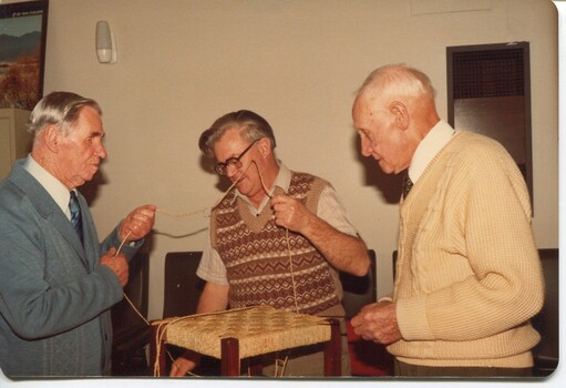 Trio of men caning a stool