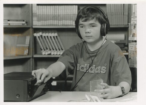 Child wearing headphones listening to a cassette player