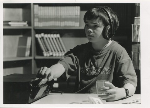 Child wearing headphones listening to a cassette player