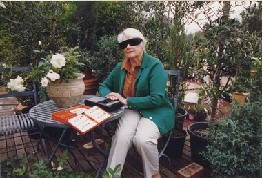 Claire Proctor with a talking book in a plant nursery