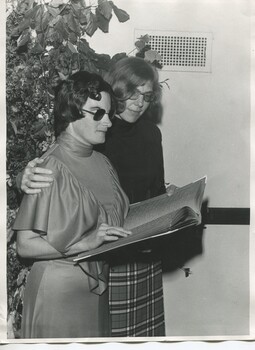 Kay White holds Braille book with Mary Rose Liverani beside her