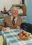 Smiling man at kitchen table with cup of tea listening to radio