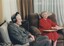 Jim wears headphones whilst Edith reads Braille in their lounge room