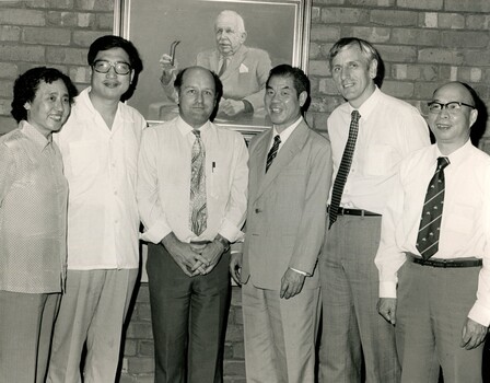 Chinese vistors, Barry Furness and John Cook stand in front of George Vowell portrait