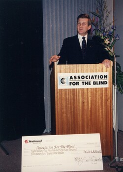 Jeff Kennett at the podium with an oversized cheque in front of him