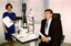Rob Knowles sits in client chair at eye examination station