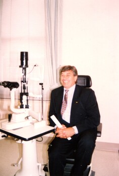 Rob Knowles sits in client chair at eye examination station