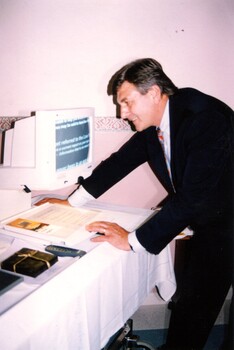 Rob Knowles views computer screen with magnifier displayed at clinic